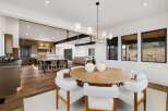 Experience modern luxury in this open-concept living space, featuring a gourmet kitchen with a large island and a sophisticated dining area.