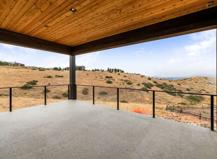 Enjoy breathtaking panoramic views from this expansive covered deck, perfect for outdoor entertaining or quiet relaxation.