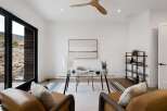 This modern home office features a sleek glass desk with a comfortable chair, perfect for productivity.