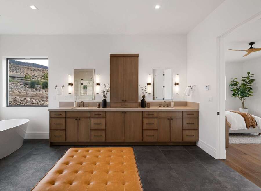 Experience luxury in this stunning master bathroom, featuring a freestanding soaking tub with a picturesque view and a spacious double vanity with ample storage.