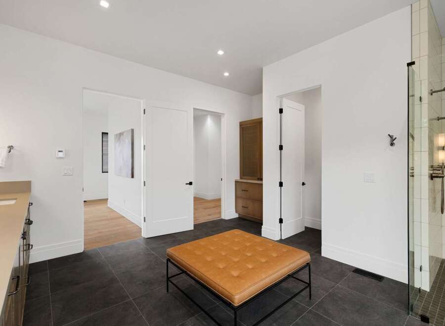 Experience modern luxury in this spacious bathroom featuring a sleek vanity and a walk-in glass shower with elegant tilework.