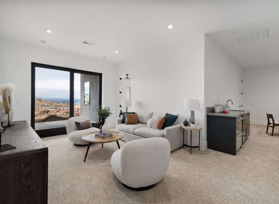 Experience modern living in this stylish living area, featuring plush seating and a sleek wet bar perfect for entertaining.