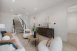 Step into this inviting living space featuring a plush white sofa adorned with accent pillows and a cozy armchair.