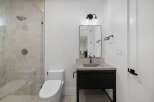 This modern bathroom features a sleek walk-in shower with elegant tilework and a rainfall showerhead.