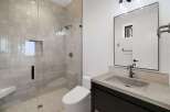 Experience modern luxury in this stunning bathroom, featuring a spacious walk-in shower with elegant tilework and a built-in bench.