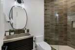 Experience modern luxury in this stunning bathroom, featuring a sleek concrete sink atop a dark wood vanity.