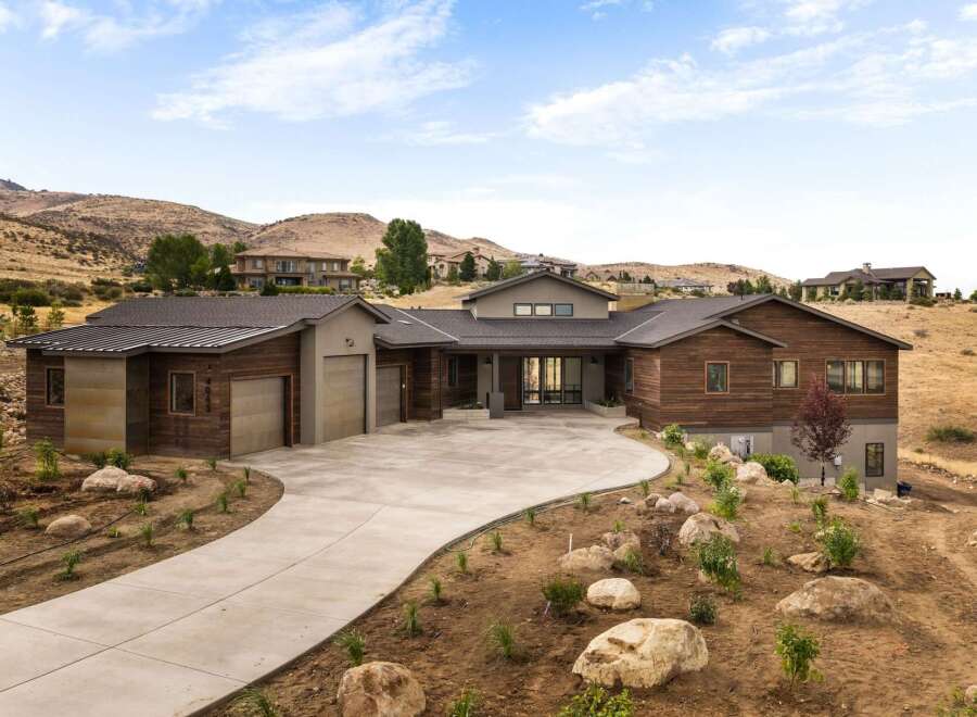 Experience luxury living in this stunning modern home nestled in a picturesque hillside setting.