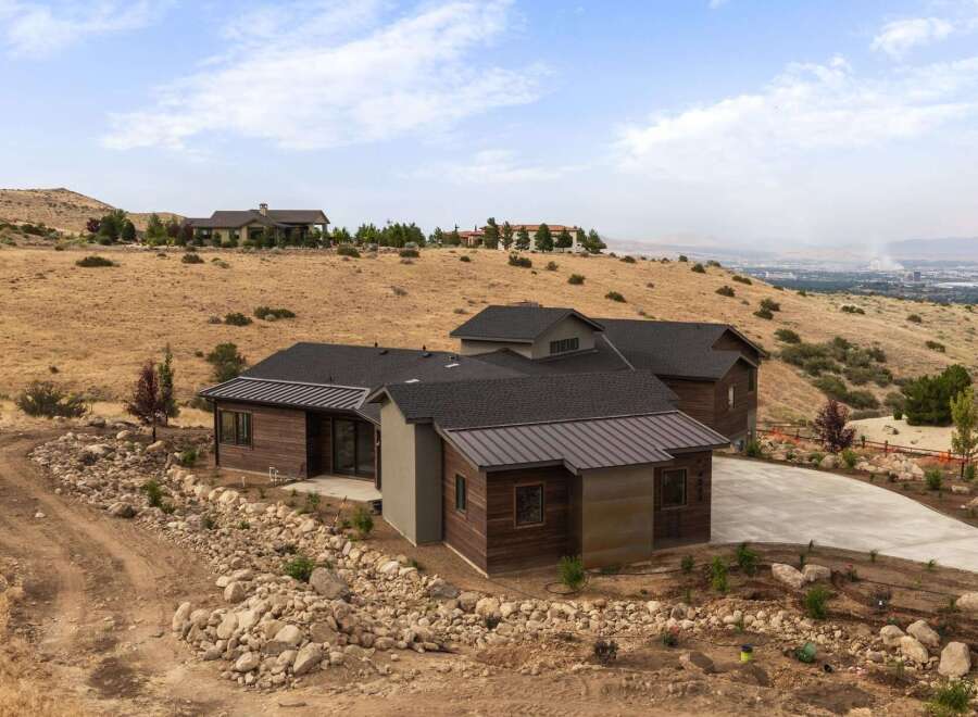 Discover modern luxury living in this stunning hillside estate, featuring a sleek contemporary design with rich wood accents and a durable metal roof.