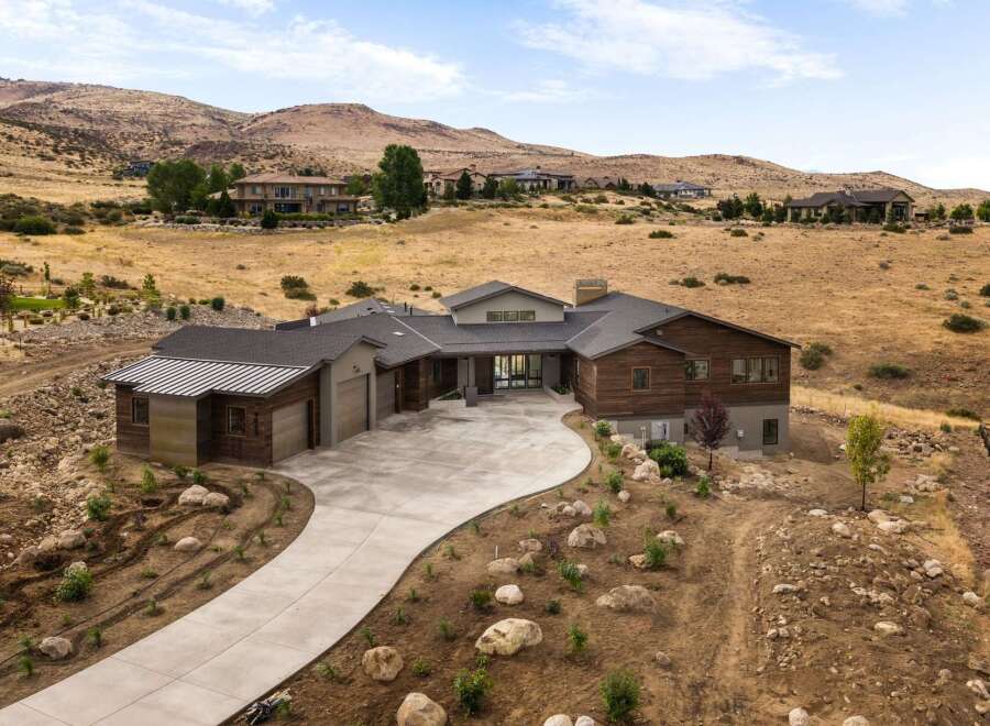 Experience luxury living in this stunning modern home nestled in a serene hillside landscape.