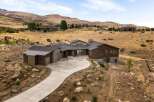 Experience luxury living in this stunning modern home nestled in a serene hillside landscape.