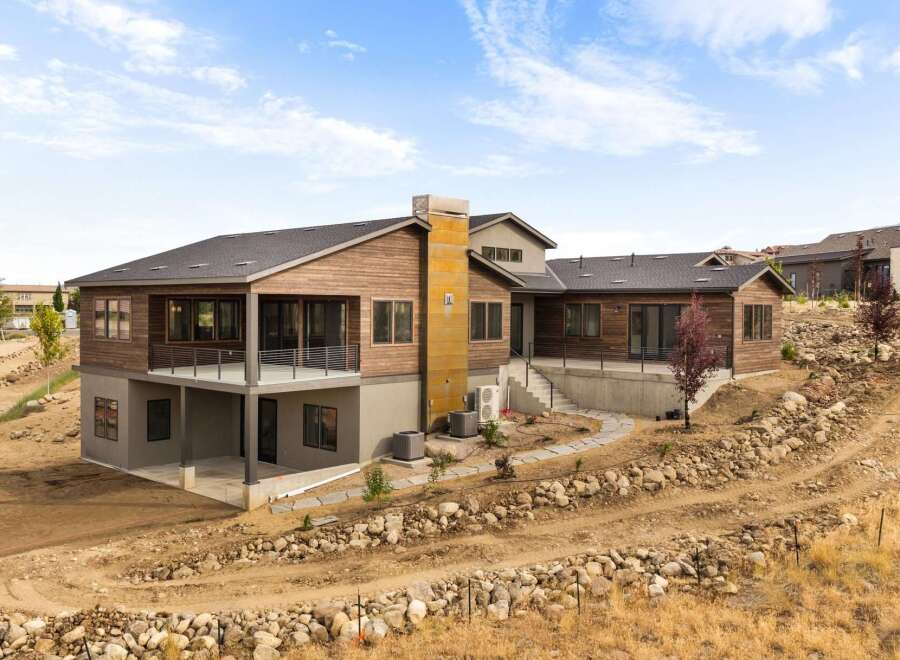 Experience modern luxury in this stunning home featuring natural wood siding and expansive windows that invite the outdoors in.
