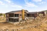 Experience modern luxury in this stunning home featuring natural wood siding and expansive windows that invite the outdoors in.