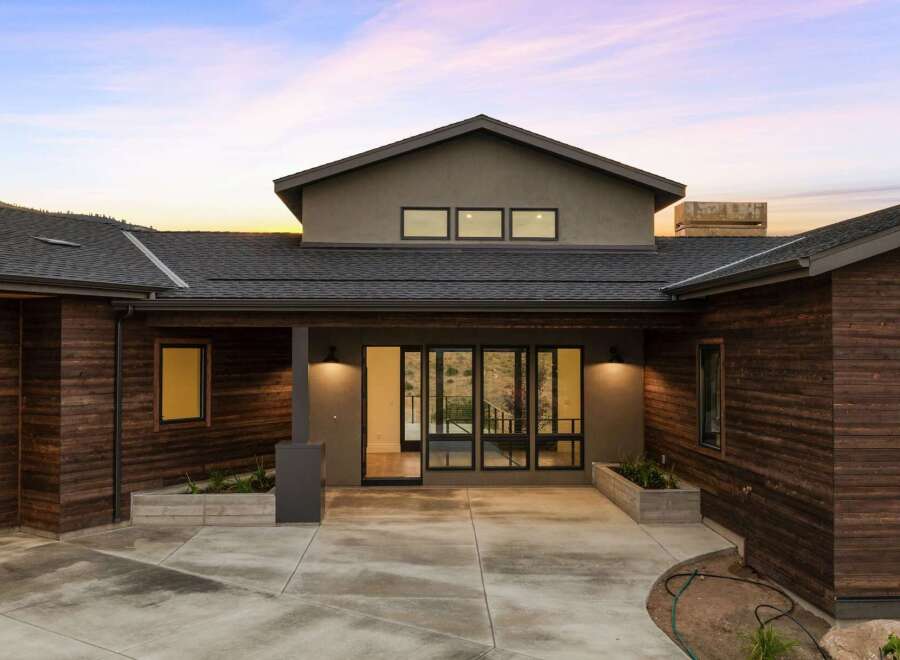 Experience modern living in this stunning home featuring rich wood siding and a sleek, contemporary design.