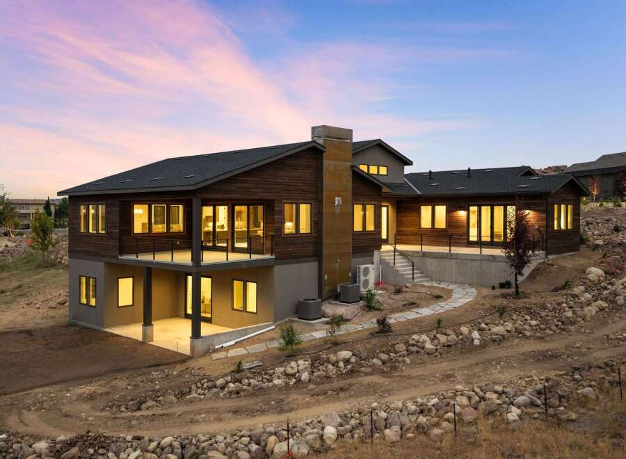 Experience modern luxury in this stunning multi-level home, featuring rich wood siding and expansive windows that capture breathtaking sunset views.