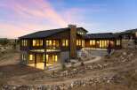 Experience modern luxury in this stunning multi-level home, featuring rich wood siding and expansive windows that capture breathtaking sunset views.