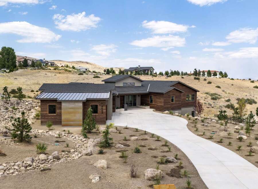 Discover modern luxury in this stunning hillside residence, featuring a striking wood and metal exterior that complements the natural desert landscape.