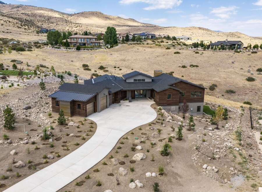 Experience luxury living in this stunning modern home, nestled in a serene hillside landscape.