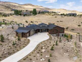 Experience luxury living in this stunning modern home, nestled in a serene hillside landscape.