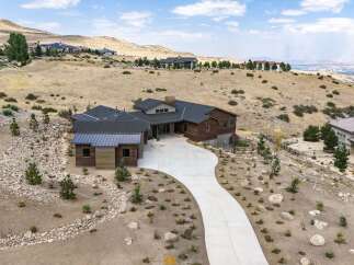 Experience luxury living in this stunning modern home nestled on a hillside with panoramic views.