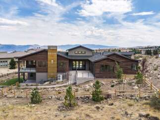 Experience modern luxury in this stunning contemporary home, featuring rich wood siding and a striking metallic chimney.