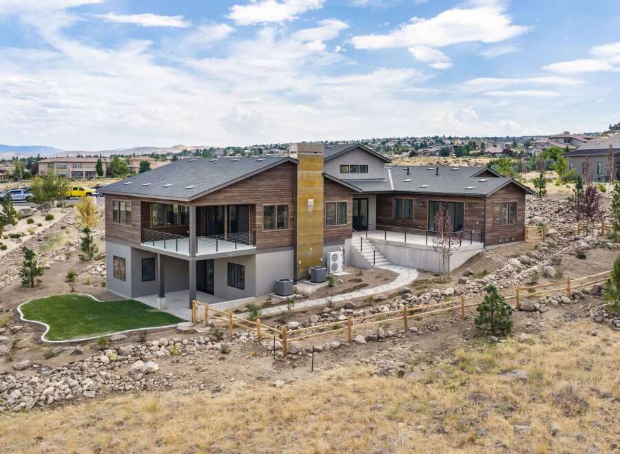 Experience modern luxury in this stunning multi-level home, featuring a striking wood and stone exterior that blends seamlessly with the natural landscape.