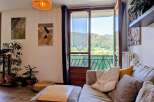 Experience breathtaking mountain views from this charming living room, featuring a comfortable sectional sofa adorned with plush pillows and a cozy throw.