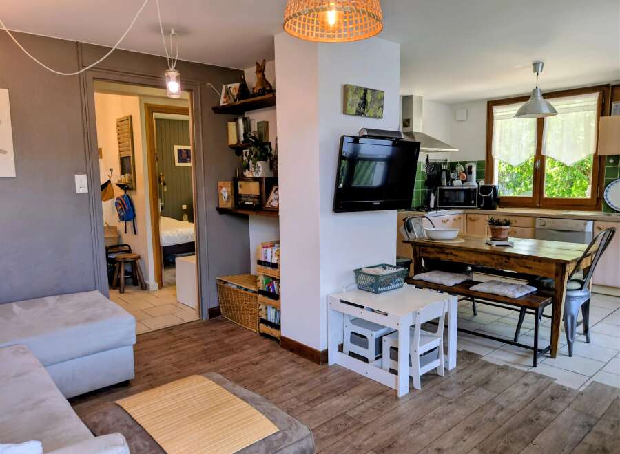 Discover this charming living space featuring a comfortable sofa and a modern kitchen area perfect for entertaining.