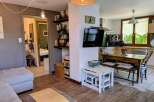 Discover this charming living space featuring a comfortable sofa and a modern kitchen area perfect for entertaining.