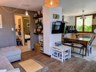 Discover this charming living space featuring a comfortable sofa and a modern kitchen area perfect for entertaining.