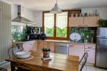 This charming kitchen features a rustic wooden dining table, perfect for family meals.