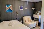 This cozy bedroom features a comfortable bed with a textured white duvet and a decorative pillow.