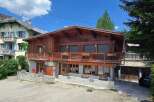 Experience alpine living in this charming wooden chalet, featuring a spacious balcony perfect for enjoying mountain views.