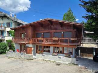 Experience alpine living in this charming wooden chalet, featuring a spacious balcony perfect for enjoying mountain views.