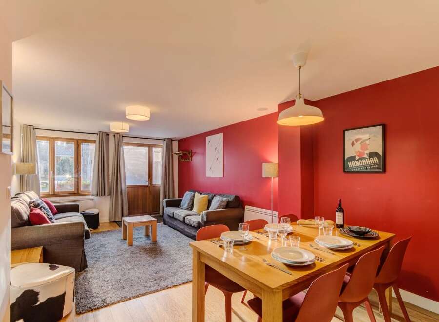 Experience comfortable living in this inviting dining and living area, featuring a spacious dining table set for meals and two plush sofas perfect for relaxation.