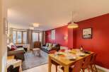 Experience comfortable living in this inviting dining and living area, featuring a spacious dining table set for meals and two plush sofas perfect for relaxation.