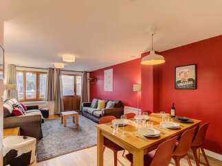 Experience comfortable living in this inviting dining and living area, featuring a spacious dining table set for meals and two plush sofas perfect for relaxation.