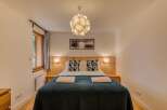 Experience cozy comfort in this charming bedroom, featuring a plush bed adorned with decorative pillows and soft throws.