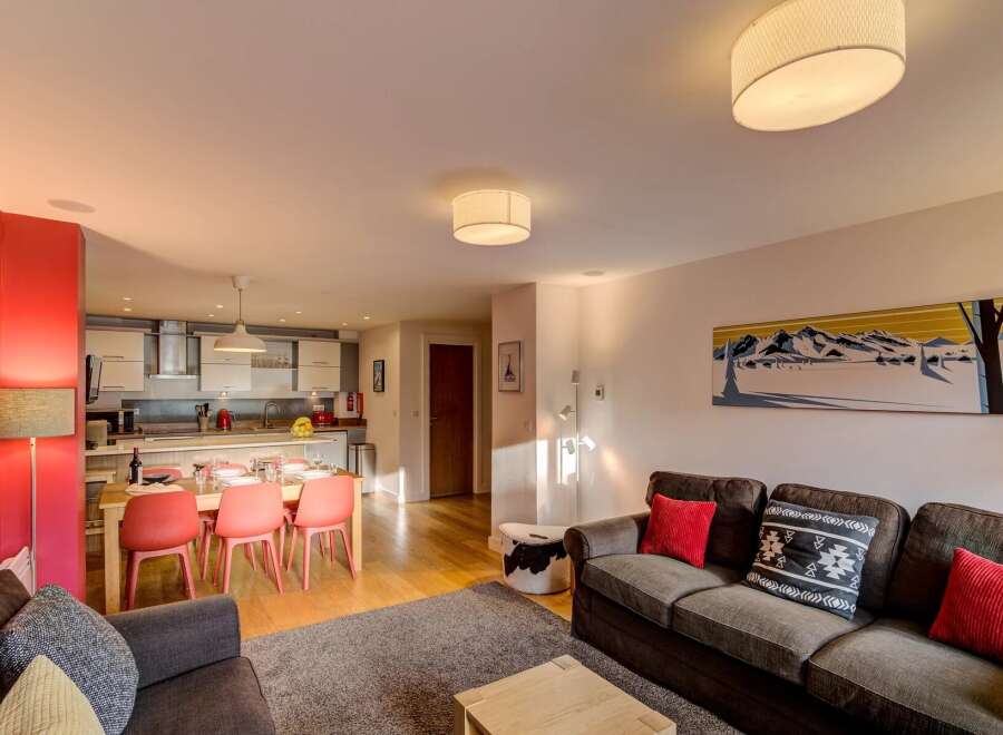 Experience modern living in this open-plan apartment, featuring a fully equipped kitchen and a spacious dining area perfect for family meals.