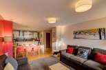 Experience modern living in this open-plan apartment, featuring a fully equipped kitchen and a spacious dining area perfect for family meals.