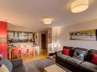 Experience modern living in this open-plan apartment, featuring a fully equipped kitchen and a spacious dining area perfect for family meals.