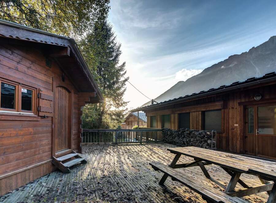 Experience the charm of mountain living with this rustic wooden cabin, featuring a spacious deck perfect for enjoying the crisp alpine air.