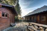 Experience the charm of mountain living with this rustic wooden cabin, featuring a spacious deck perfect for enjoying the crisp alpine air.