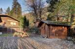 Experience rustic charm in this mountain retreat featuring a cozy wooden cabin and a spacious deck perfect for outdoor gatherings.