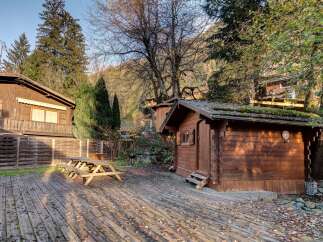 Experience rustic charm in this mountain retreat featuring a cozy wooden cabin and a spacious deck perfect for outdoor gatherings.