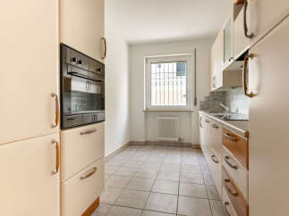 This kitchen features a built-in oven and ample cabinet space, perfect for storage and meal preparation.