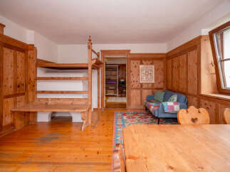 Experience rustic charm in this inviting living space featuring warm wooden paneling and a cozy seating area.
