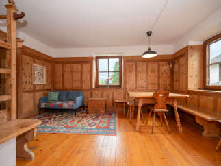 Experience rustic charm in this inviting living and dining area, featuring warm wood paneling throughout.