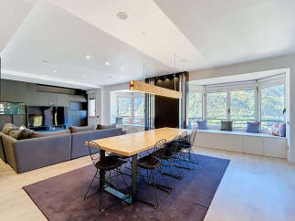 Experience modern living in this spacious open-concept home, featuring a comfortable living area with a large sectional sofa and entertainment unit.