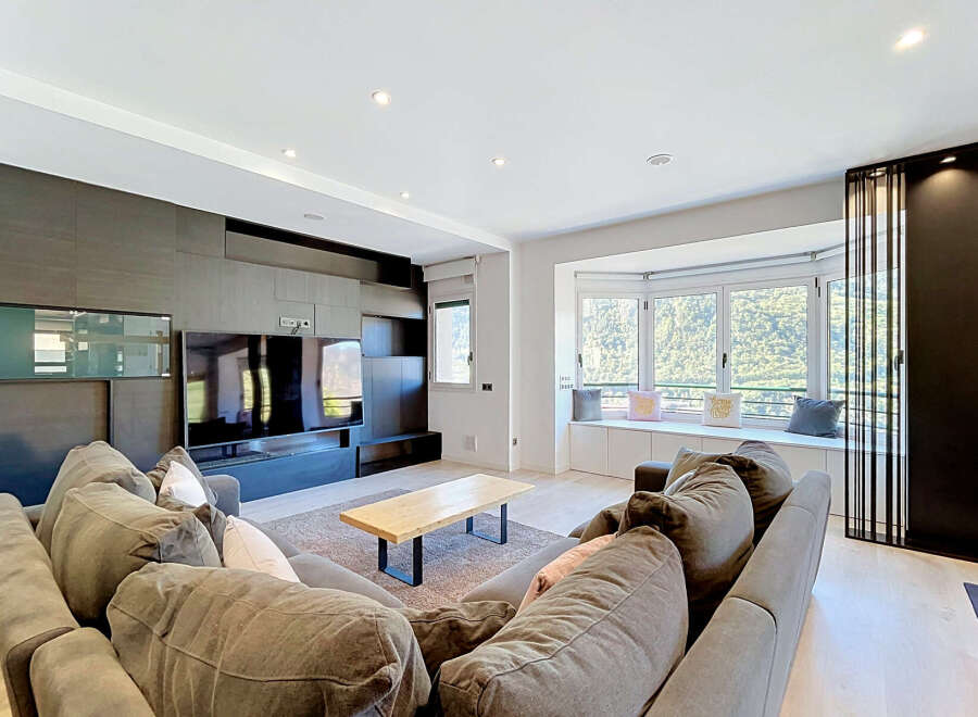 Experience modern living in this spacious living room, featuring a large sectional sofa perfect for gatherings and a sleek entertainment center.