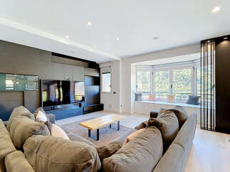 Experience modern living in this spacious living room, featuring a large sectional sofa perfect for gatherings and a sleek entertainment center.